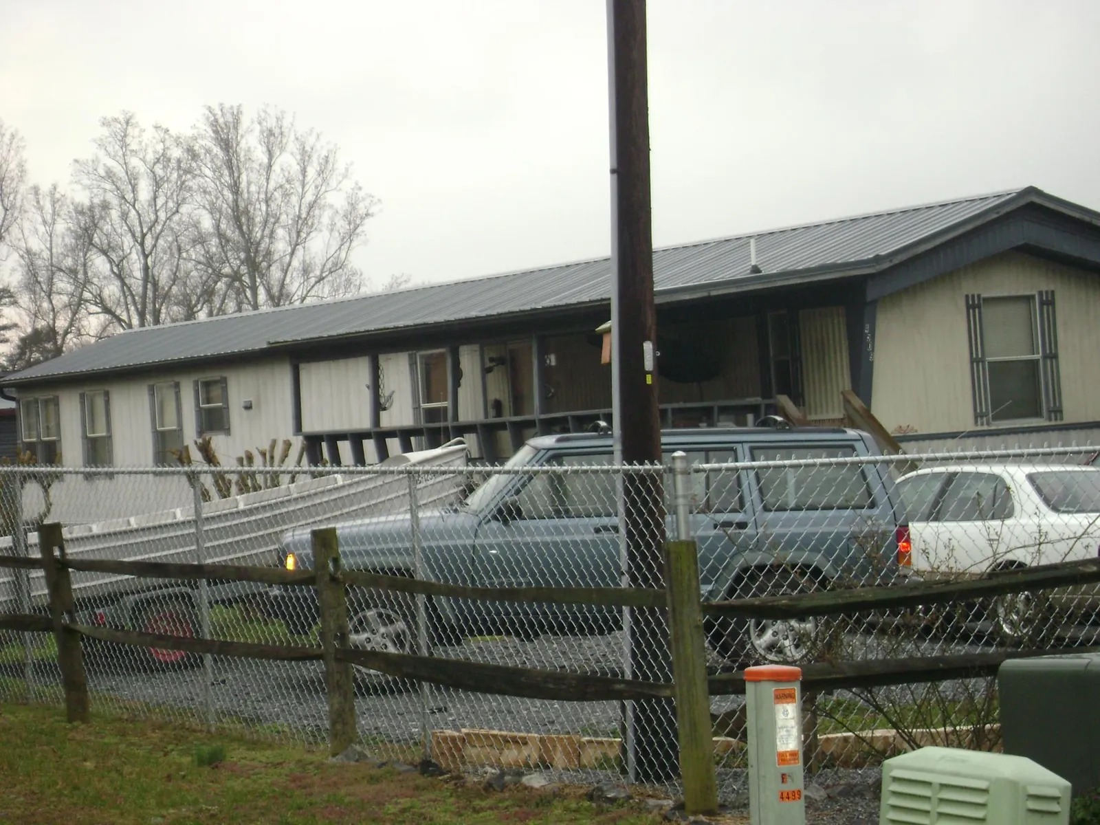 Dark metal roof on a long single story building behind a chain link fence in Millington